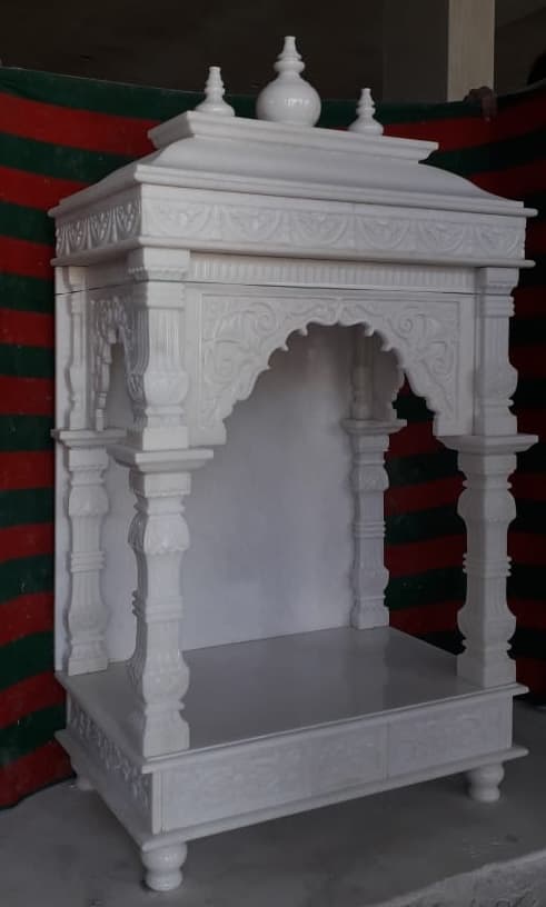 Marble mandir with carved pillars, arched canopy and dome finials